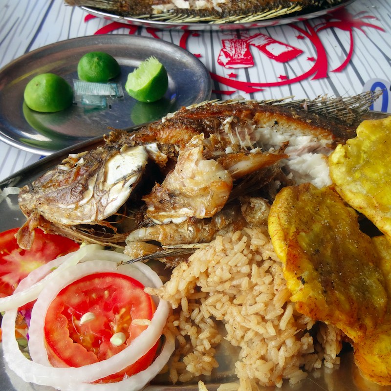 local food: plate of cooked fish with plantains, tomatoes and onions in Cartagena