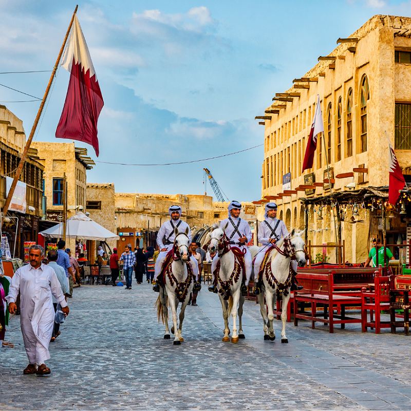 men riding horses at the souk in Qatar during the day