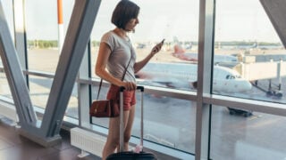 Woman Checking Phone at Airport