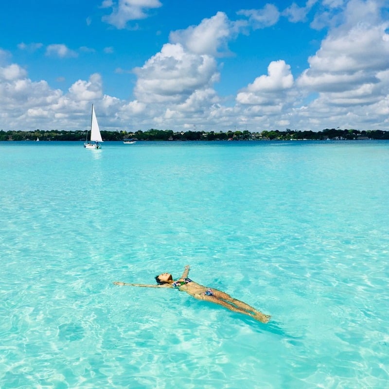 Young Woman Lying On Her Back In The Bacalar Lagoon, Bacalar, Mexico