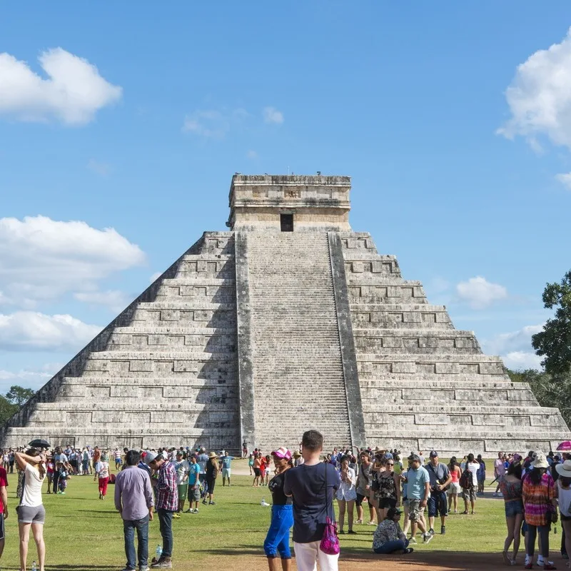 A Crowd Of Tourists Gathering At The Bottom Of The Chichen Itza Pyramid In Quintana Roo, Mexico