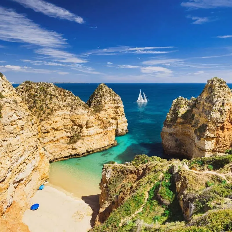 Aerial View Of A Sandy Atlantic Beach Bounded By Tall Cliffs In Lagos, Southern Portugal, Western Europe