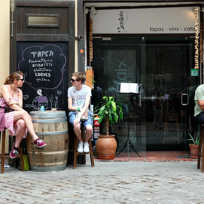 Tourists sitting outside at a cafe sidewalk in Barcelona, Spain. 