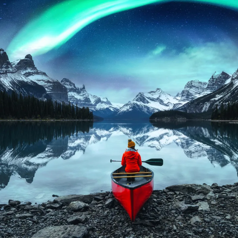 female tourist seeing northern lights in canada
