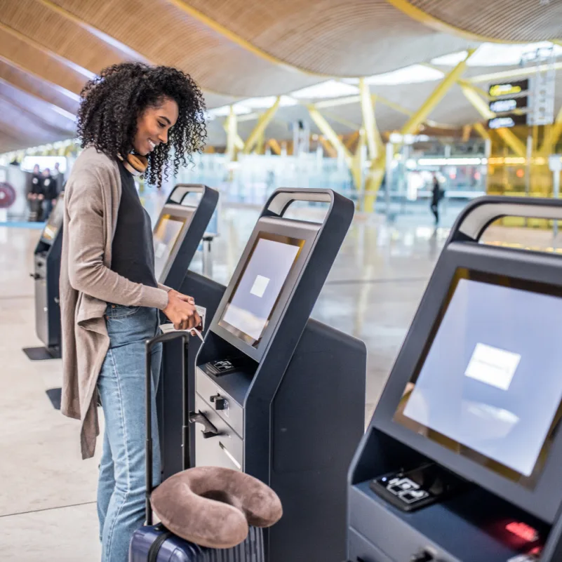 happy woman using self check in at the airport