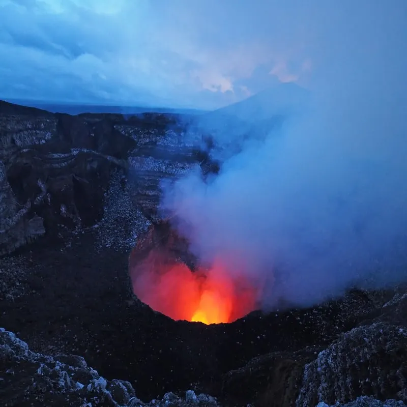 Masaya Volcano with visible lava pool and glowing exhaust fumes and gases in twilight, Masaya, Nicaragua, Central America.