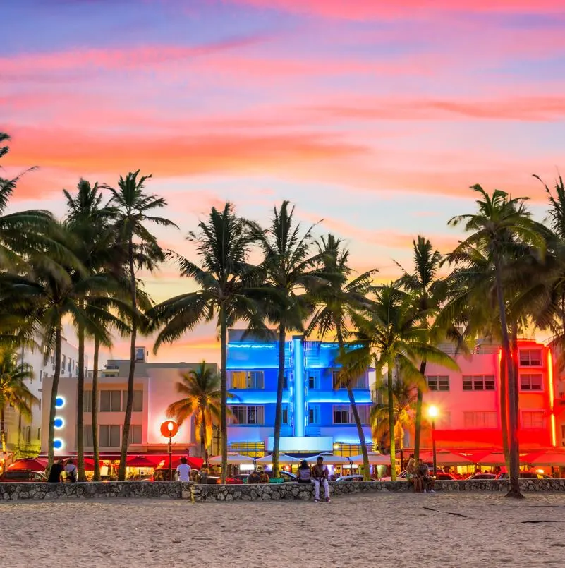 Miami beach with lit up buildings in the background