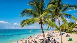 People enjoy Doctor's Cave Beach in Montego Bay Jamaica on a sunny day.