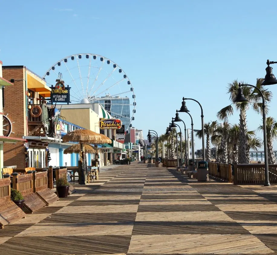 checkered path, beach promenade, blue sky and ferris wheel in the background