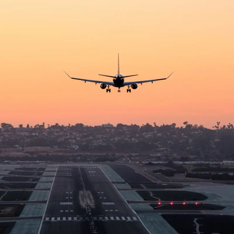 plane coming in to land at san diego airport at sunset