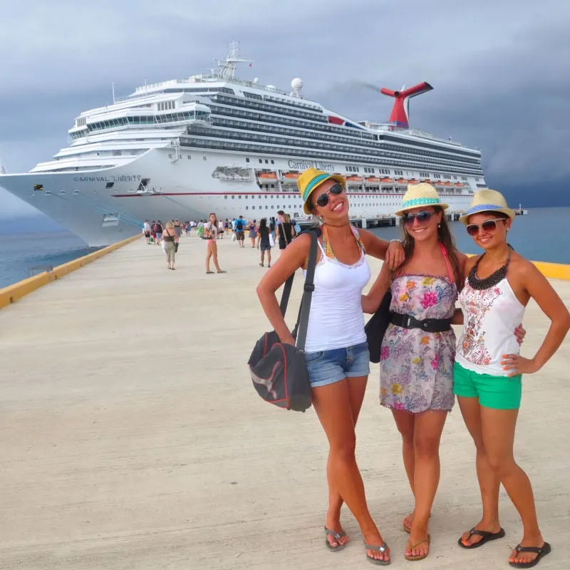 Three women posing in front of a cruise