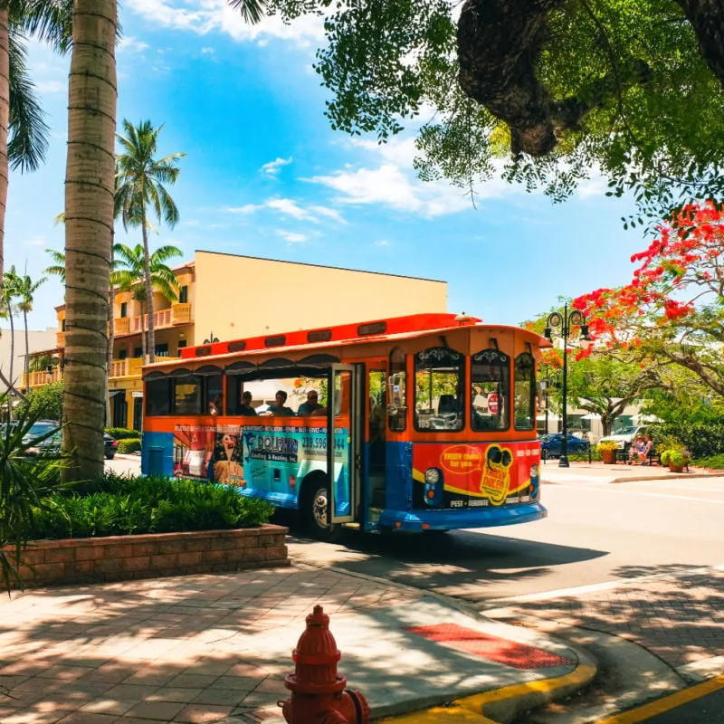 trolley driving along a sunny street in naples florida