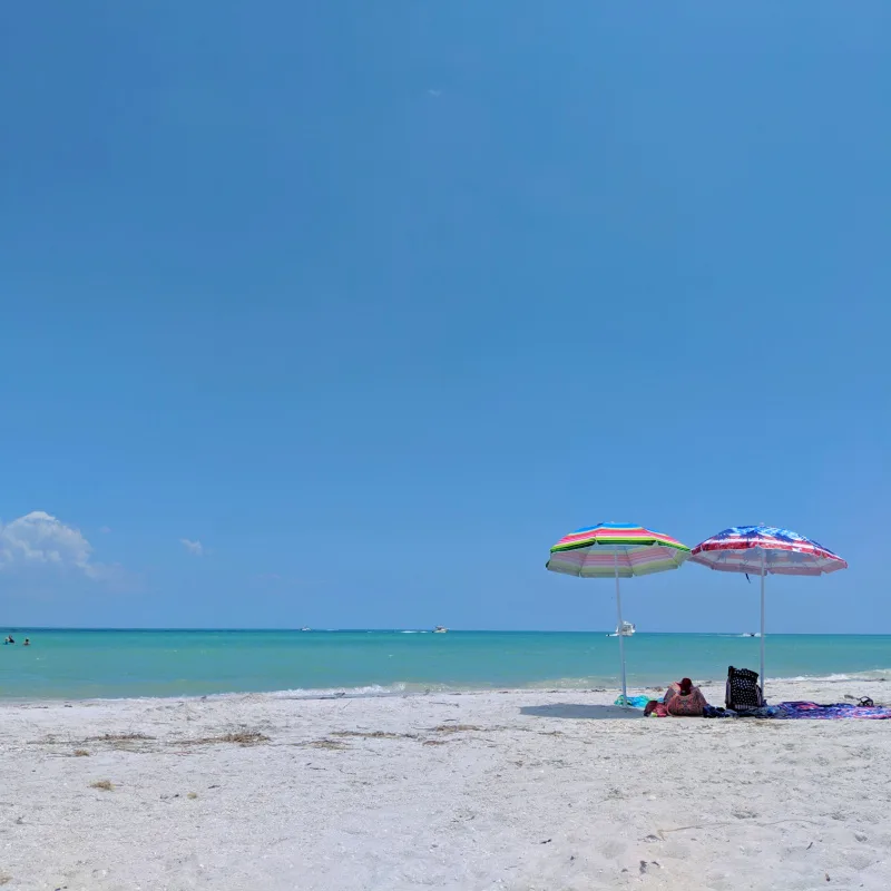 two umbrellas under clear blue skies at sanibel island florida