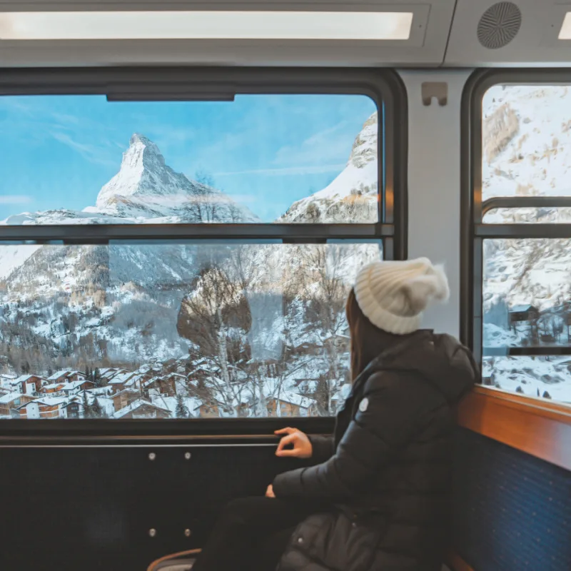 woman in train watching mountains