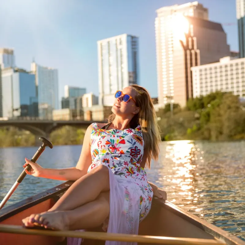 woman on canoe boat kayak relaxing enjoying summer fun day on river in Austin downtown