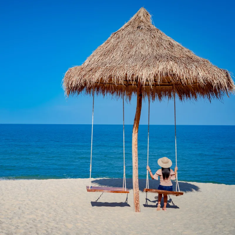 woman on swing at sichon beach thailand