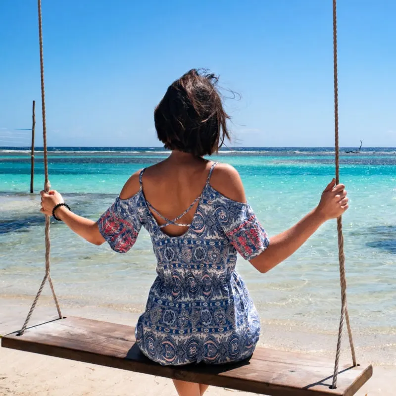 woman sitting on a swing in Mahahual, mexico