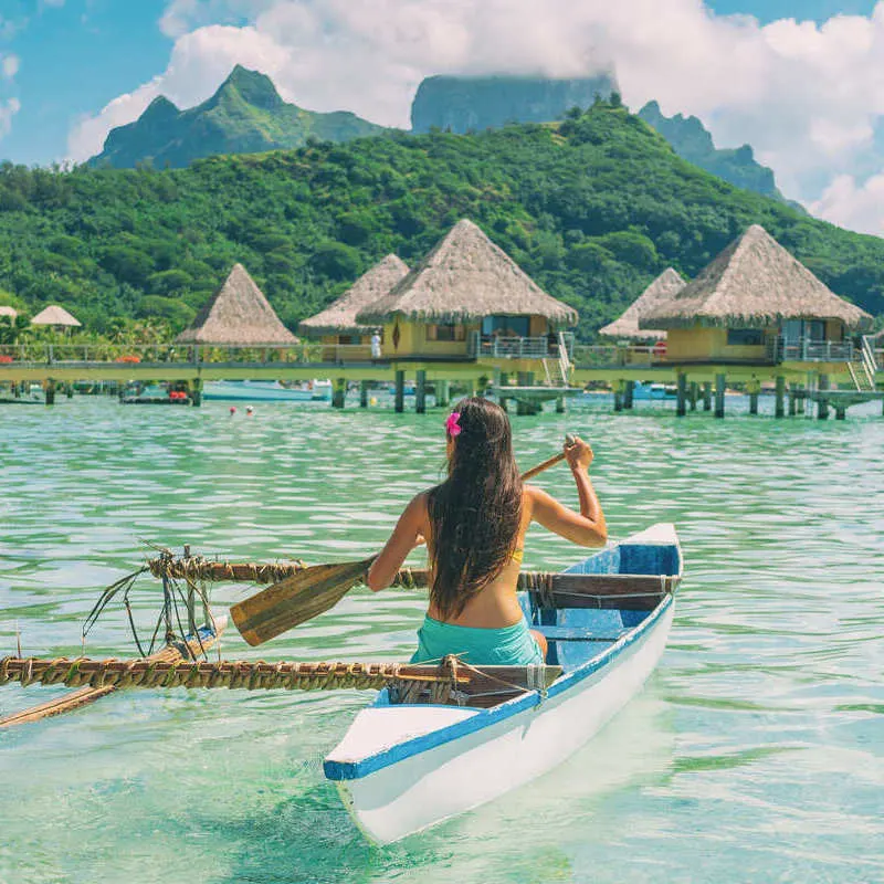 Young Woman Kayaking In Bora Bora, French Polynesia